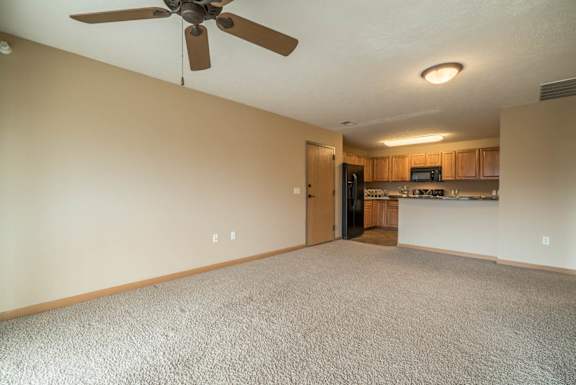 a empty living room with a ceiling fan