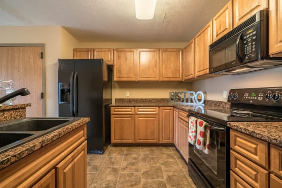 a kitchen with black appliances and wooden cabinets