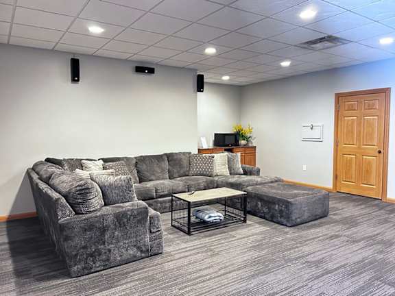 a theater room with a grey couch, and a microwave for snacks