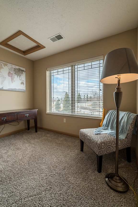 a living room with a lamp and a chair and a window