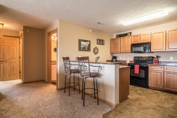 a kitchen with a bar with three stools