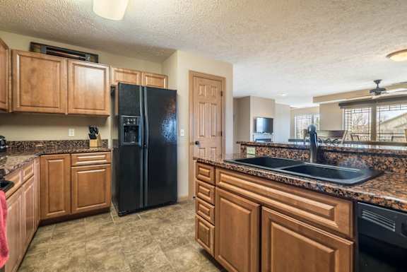 a kitchen with wooden cabinets and a black refrigerator