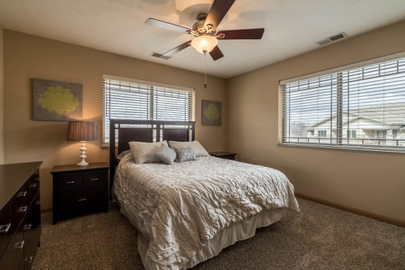 a bedroom with a bed and a ceiling fan