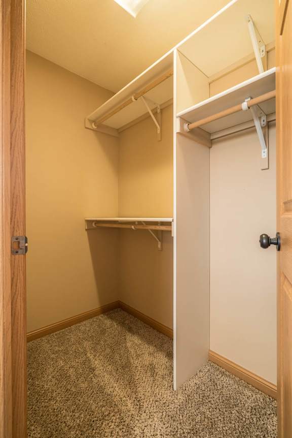 a walk in closet in a home with a door open