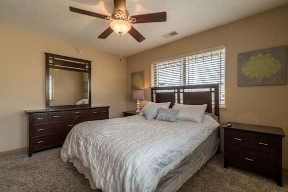 a bedroom with a large bed and a ceiling fan