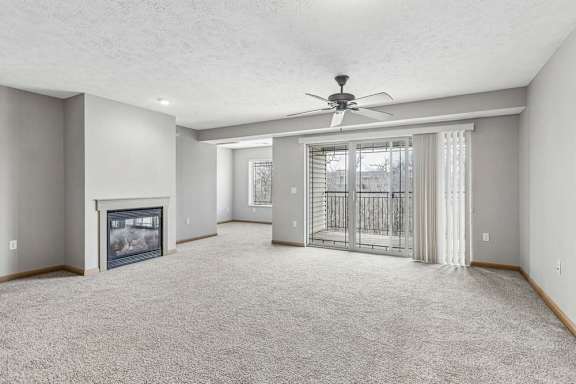 Open apartment living area featuring a fireplace and balcony access.
