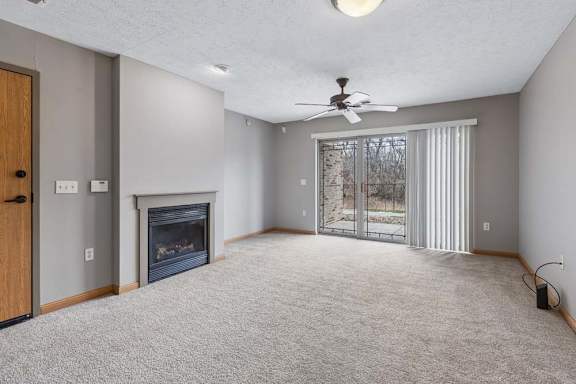 A spacious living room with a fireplace and sliding glass doors.