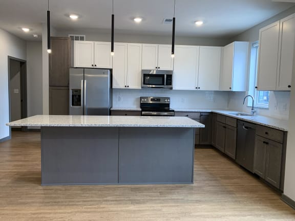 Kitchen with white cabinets and floating island at haven at uptown in lincoln nebraska