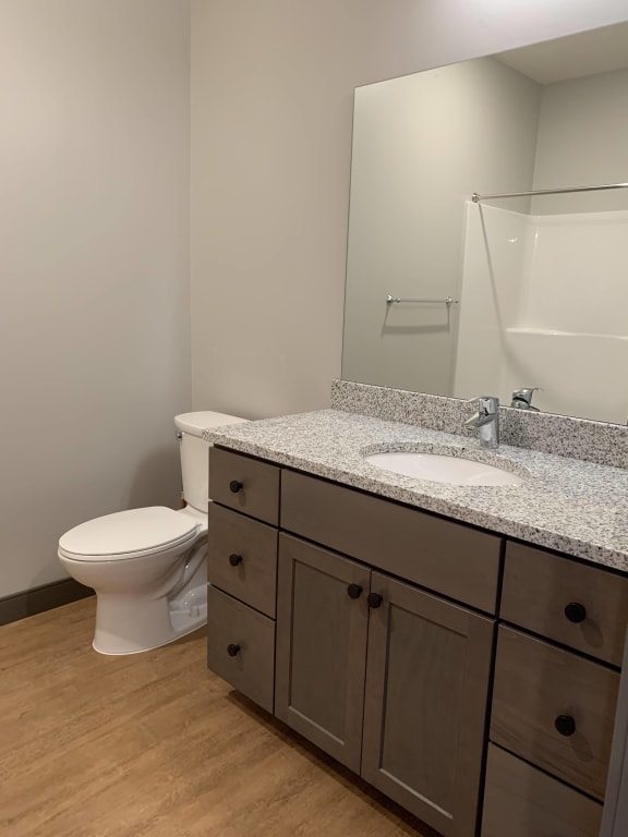 Bathroom with light brown cabinetry and granite counter tops