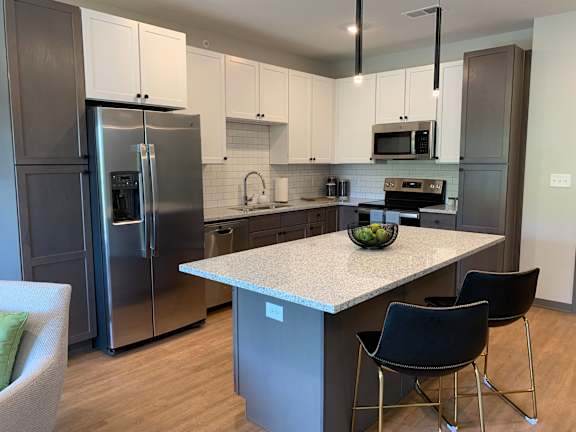 Large light finish kitchen with island and matching stainless steel appliances at haven at uptown in lincoln nebraska