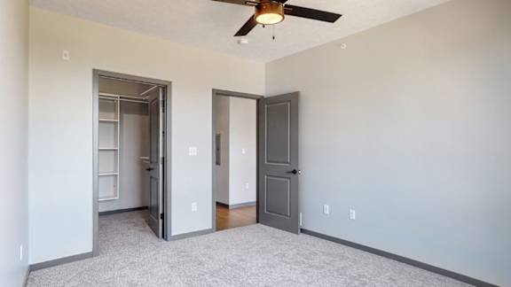 View of attached walk in closet and hallway from bedroom in Melody floor plan at Haven at Uptown