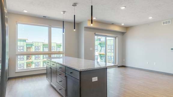 View of the connected kitchen and living space with a view of cabinet storage in the island at Haven at Uptown in Lincoln, NE