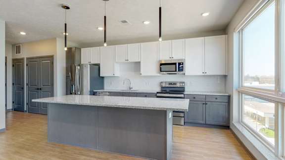 Long island in kitchen providing additional seating in the Melody floor plan at Haven at Uptown in Lincoln, NE