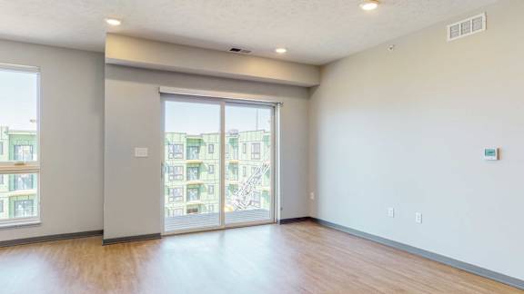 Sliding glass doors leading to a balcony in the living space of the Melody floor plan at Haven at Uptown in Lincoln, NE
