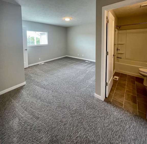 a bedroom with a carpeted floor and an attached bathroom