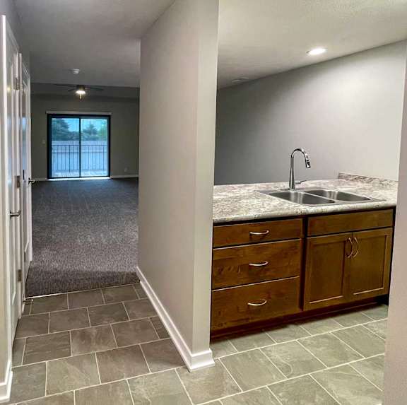 a kitchen with updated cabinets, countertops and flooring off the main entryway