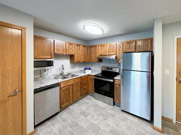 A kitchen with wooden cabinets and stainless steel appliances.
