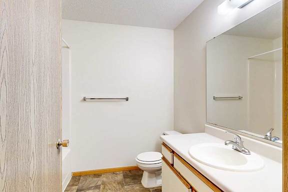 Bathroom with single-sink vanity, wide mirror, and towel bar