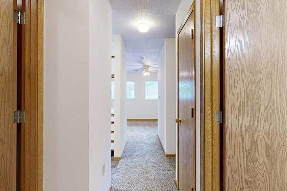 Carpeted entry hallway with built-in storage and closets