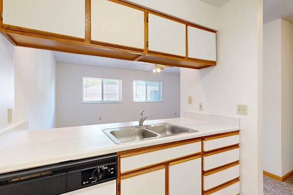 Kitchen with a passthrough window countertop and a stainless steel sink