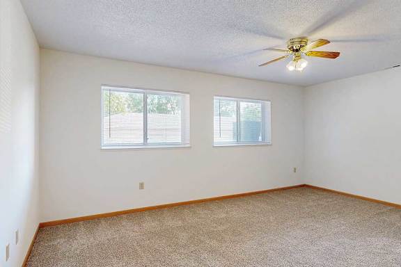 Sleeping area with two windows and ceiling fan