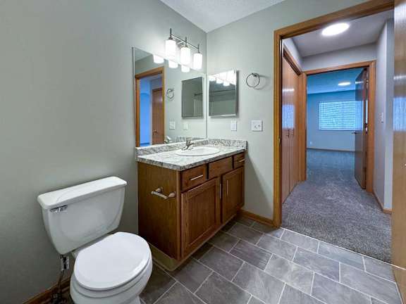 a bathroom with a vanity sink, mirror, overhead lighting, and a medicine cabinet