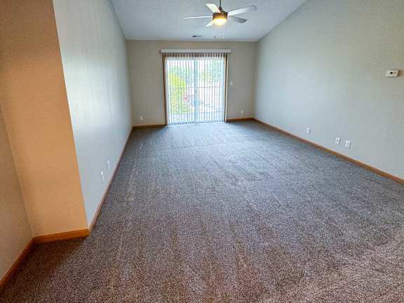 a living room with a ceiling fan and carpeted floor