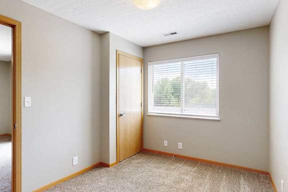 a small den or office nook with window and gray carpet