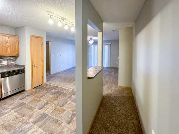 A kitchen with a windowed divider wall, creating a hallway space for the main entry.