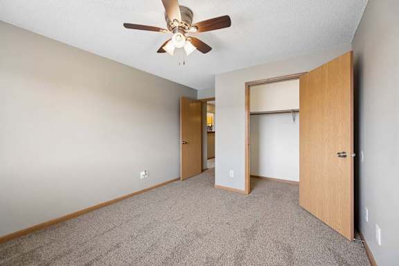 A room with a ceiling fan and two doors.