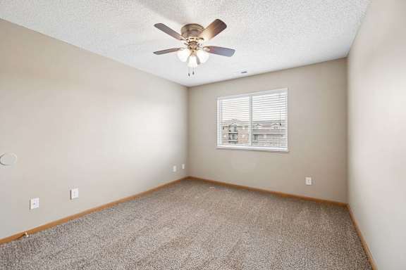 A room with a ceiling fan and a window with blinds.