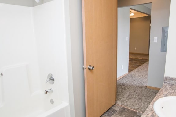 a bathroom with a door open to a shower and a sink