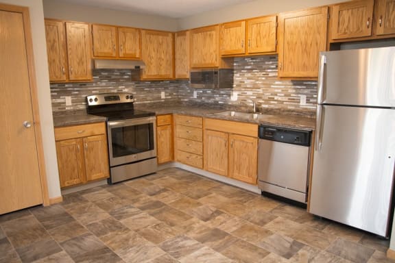 a kitchen with wooden cabinets and stainless steel appliances