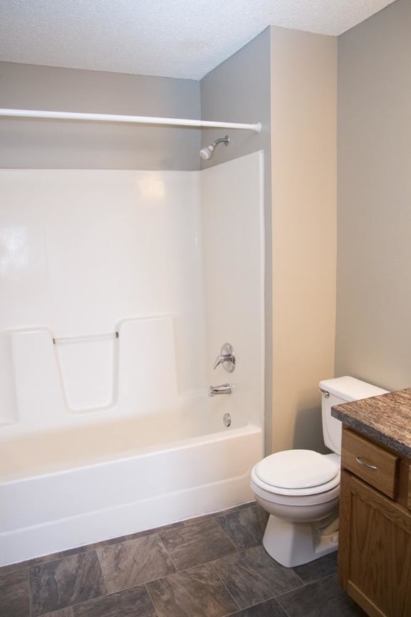 a bathroom with a toilet and a tub and a sink