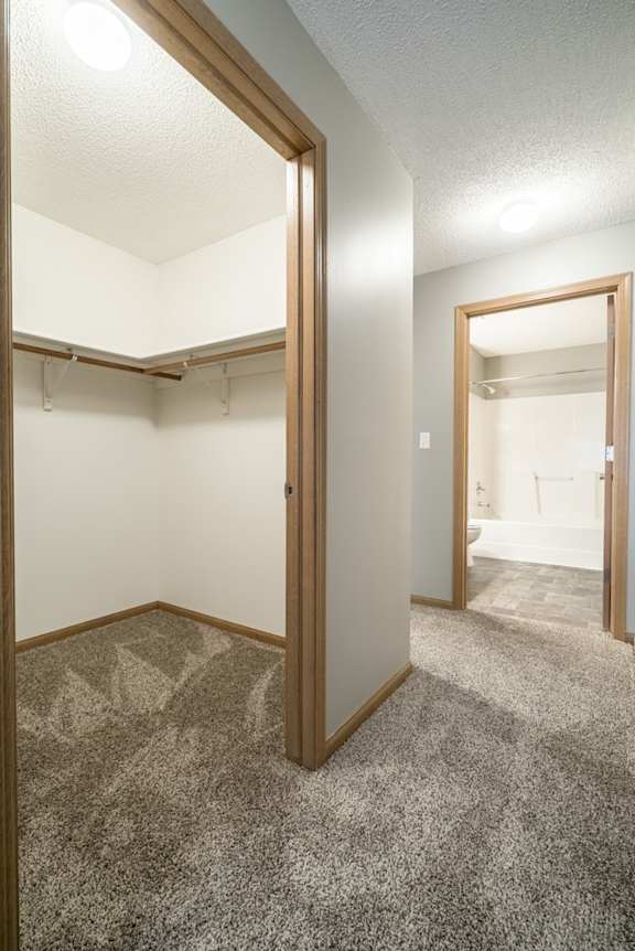 a walk-in closet in the second bedroom and a door open to the attached bathroom