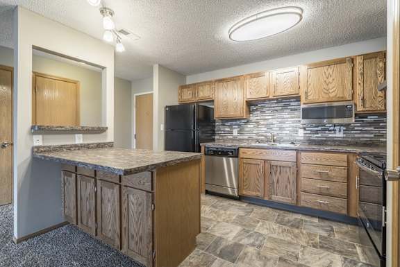 a renovated kitchen with tile backsplash and new appliances