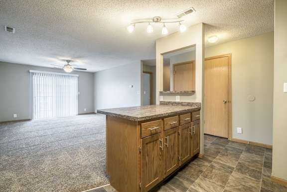 an open living room and kitchen with a door to a bedroom