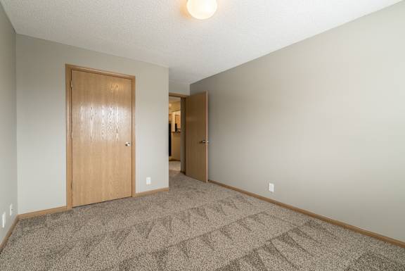a bedroom with a carpeted floor and a walk-in closet