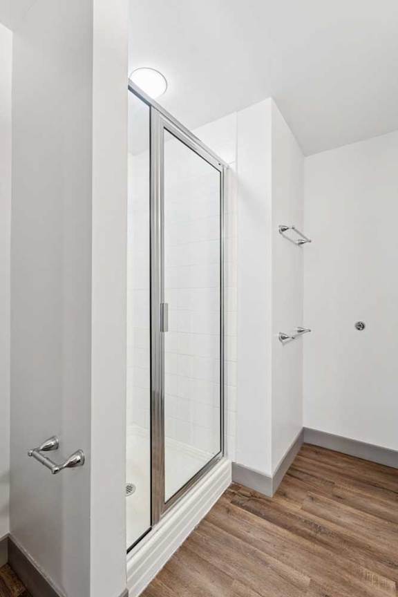 An attached bathroom featuring a walk-in shower with a glass door.