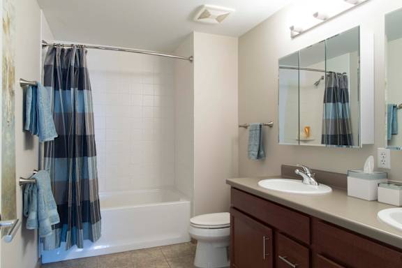 Bathroom with double sink vanity and white tub/shower