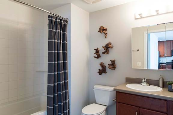 A bathroom with a toilet, sink, and a shower with a curtain.