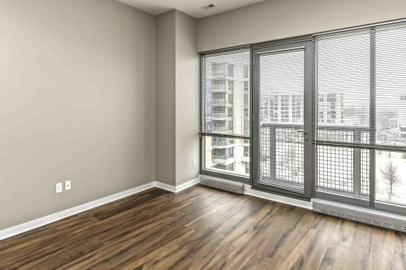 floor to ceiling windows in a living room with warm brown wood floors