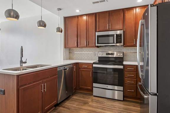 A modern kitchen with wooden cabinets and stainless steel appliances.