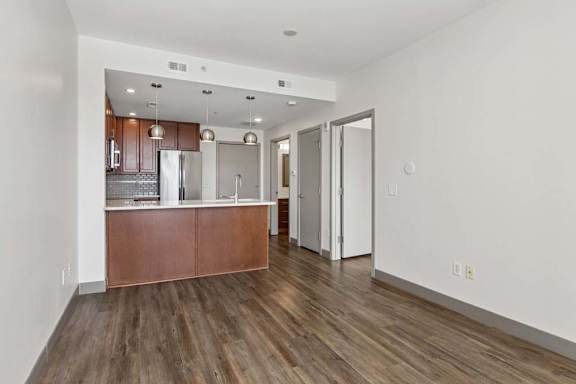 A kitchen with a wooden floor and white walls.