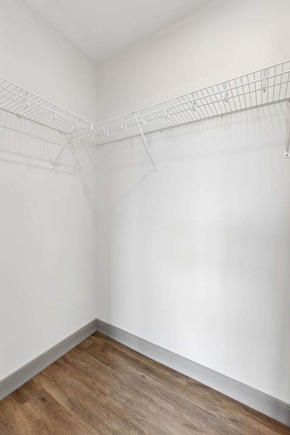 Empty closet with a white wall and a white shelf.