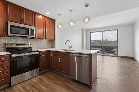 A modern kitchen with wooden cabinets and stainless steel appliances.