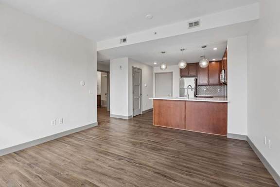 A kitchen with white walls and wooden floors.