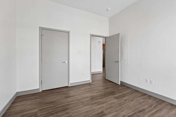 A bedroom with two doors and one open door.