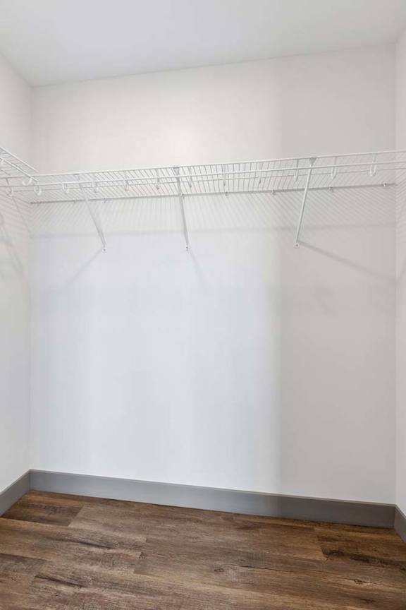 Empty closet with a white wall and a shelf.