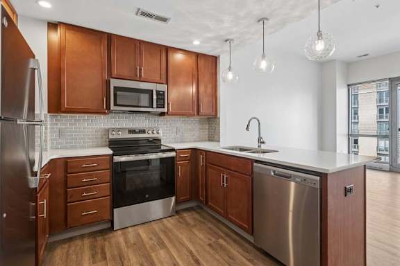 A modern kitchen with wooden cabinets and stainless steel appliances.